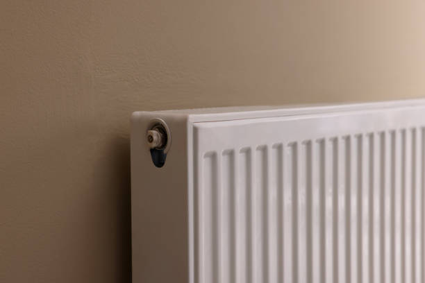 istock Modern radiator on beige wall, closeup. Central heating system 1455724995