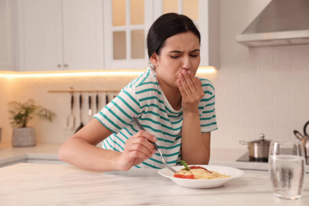 istock Young woman feeling nausea while eating at table in kitchen 1455725125