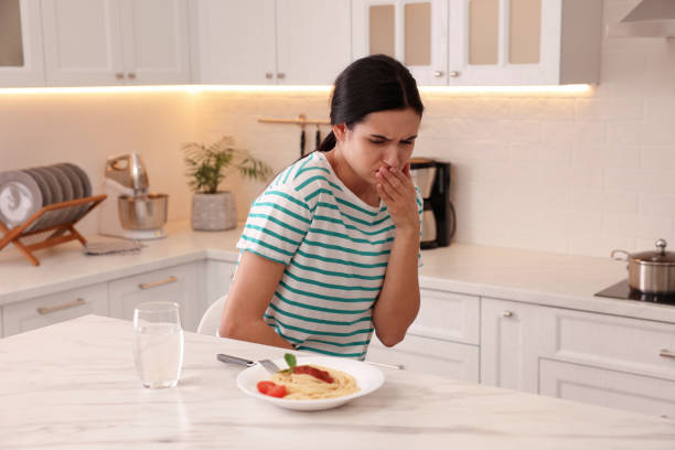 istock Young woman feeling nausea while seeing food at table in kitchen 1455725128