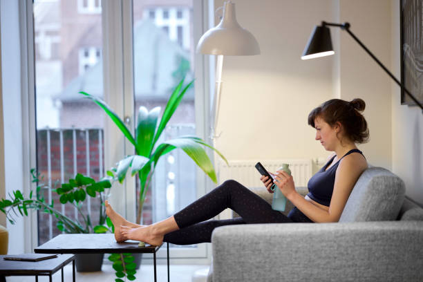 istock Sitting on sofa with mobile phone and water bottle 1455725222