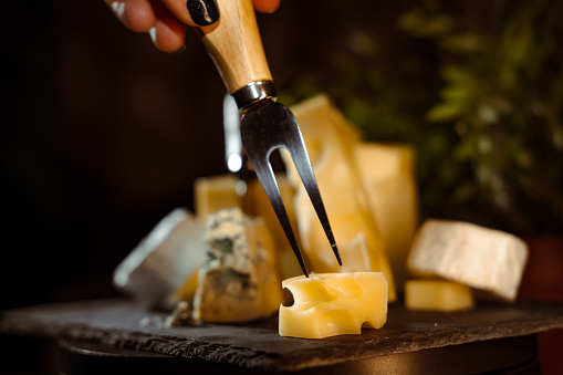 Cheese variety, many different types of cheeses on black background.