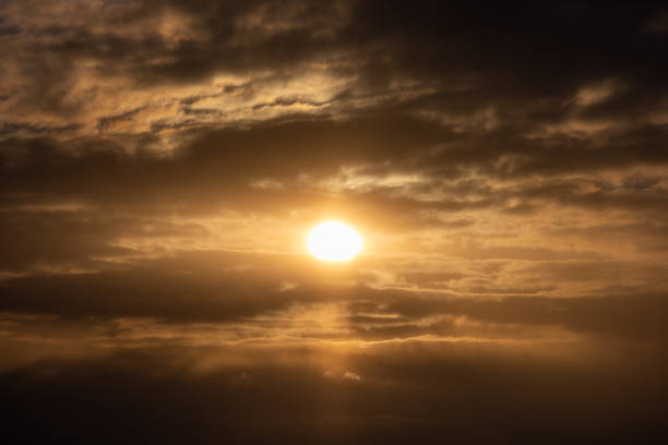 istock Beautiful golden sunset peaking through the cloudy sky on a bright summer day 1455725353