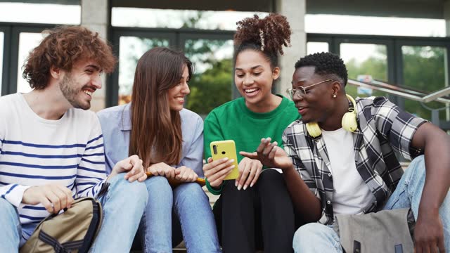 Group of university student friends sitting together using mobile phones to share content on social media