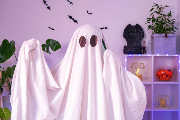 istock The Halloween Ghost uses a mobile phone for calls, congratulations, intimidation. The ghost makes an order from smartphone on Halloween. Funny Halloween concept. 1455728178