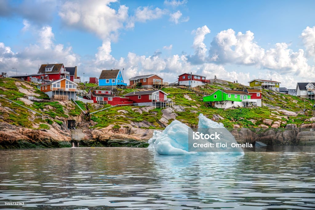 Iceberg floating in front of Ilulissat, Greenland icebergs floating in front of Ilulissat village with colourful houses, View from a boat, Greenland Greenland Stock Photo