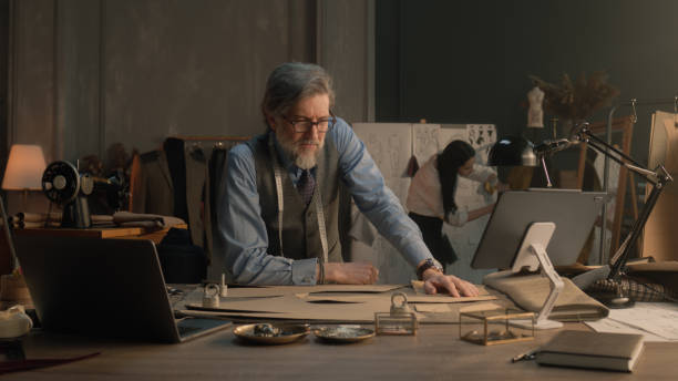 istock Tired male tailor sits at table in atelier 1455732237
