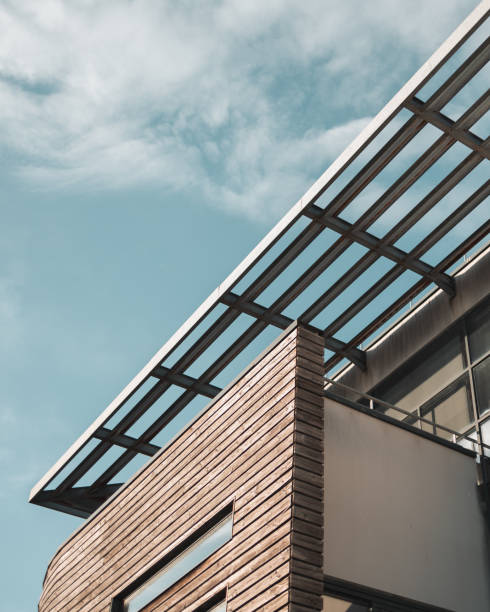 istock Low angle shot of a modern building with a balcony under a blue sky 1455735485
