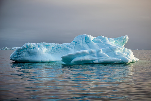 iceberg floating on water in the arctic sea at sunset at Ilulissat icefljord, Greenland