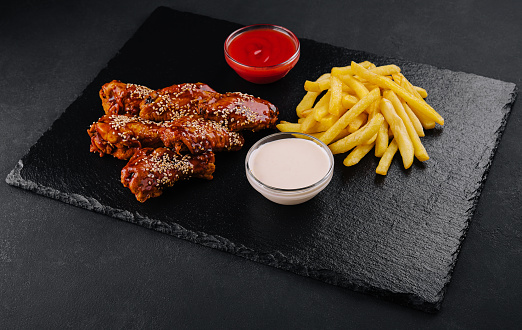 Hot and spicy buffalo chicken wings and french fries
