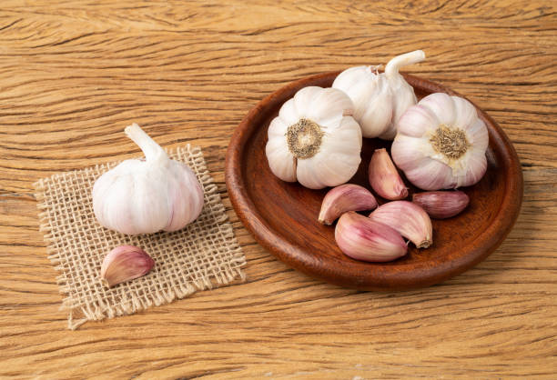 istock Garlic bulb and cloves on a plate over wooden table 1455737510