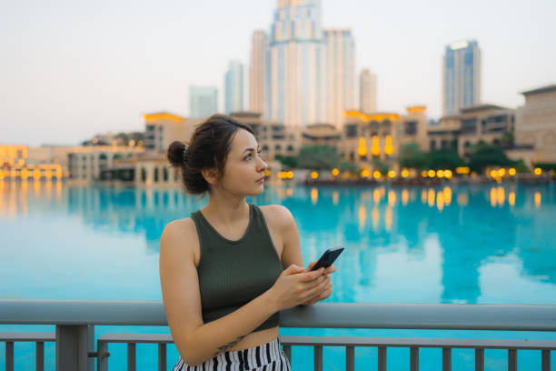 istock Woman holding smartphone while exploring Dubai 1455738719