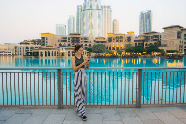 istock Woman holding smartphone while exploring Dubai 1455738756
