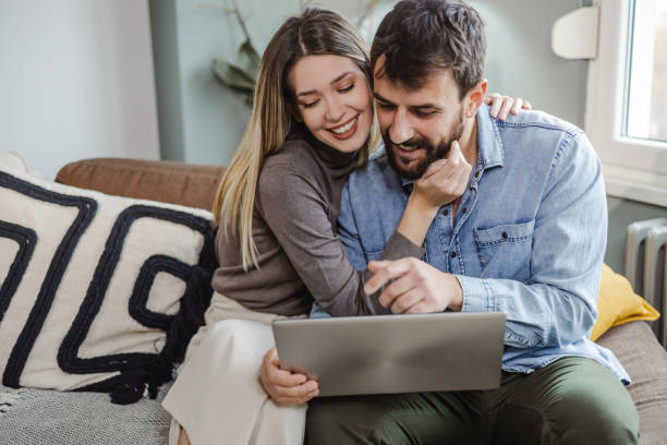 istock Young couple using laptop at home 1455738922