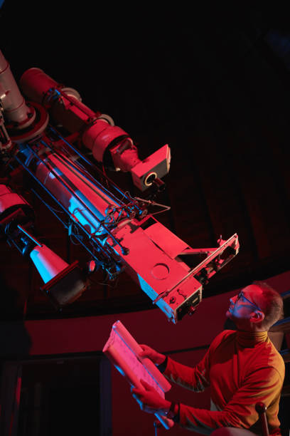 istock Astronomer with a big astronomical telescope in observatory doing science research of space and celestial objects. 1455741867