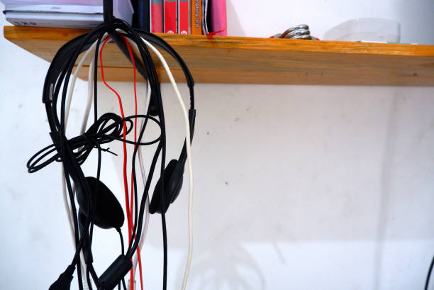 istock Cables organized and hanging on a wall-mounted bookshelf 1455745008
