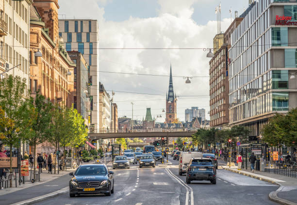 Stockholm, Sweden - Busy daytime car traffic on the street in Stockholm's city centre, with part of the city's skyline visible on the horizon.