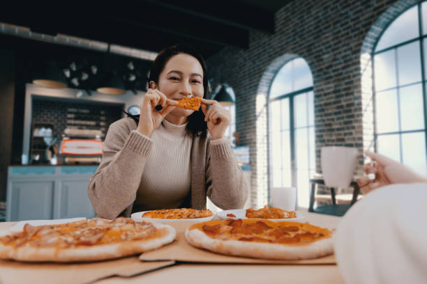 istock female hand holding slice of pizza 1455746948