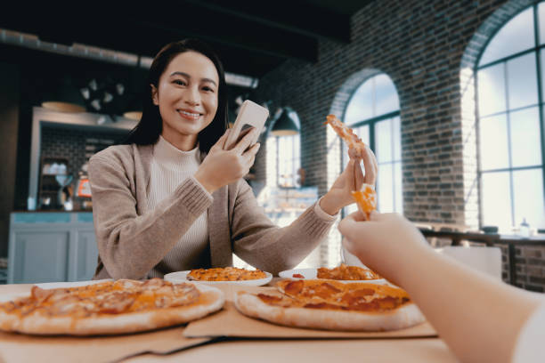 istock female hand holding slice of pizza 1455747512