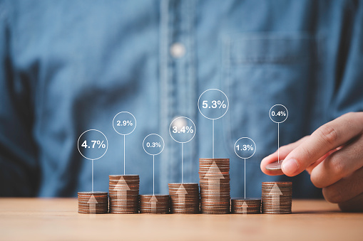 Businessman stacking coins in different height with percentage for interest rating from differ investment , Financial profit return and dividend concept.