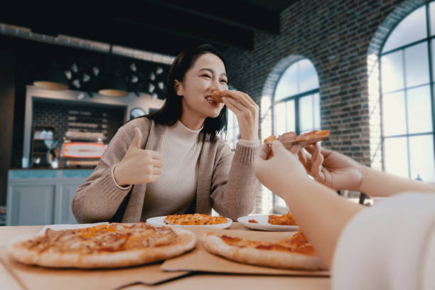 istock female hand holding slice of pizza 1455747565