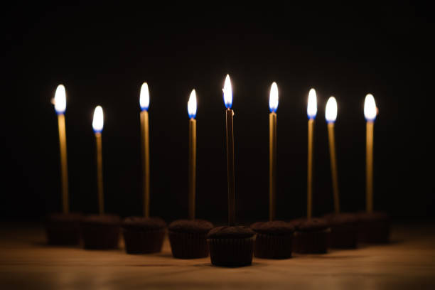 Burning birthday candles on black background