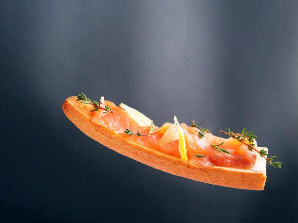 Sandwich with salmon and lemon isolated on black background
