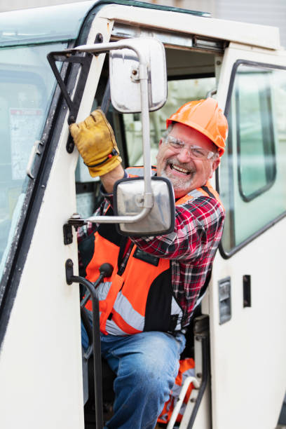 istock Senior man operating a crane, smiling at camera 1455753182