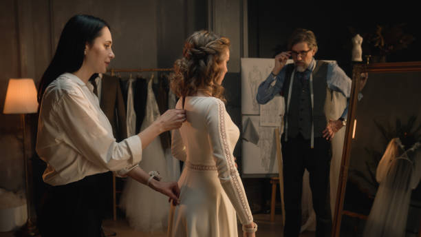 istock Tailor zips up wedding dress on woman 1455753381