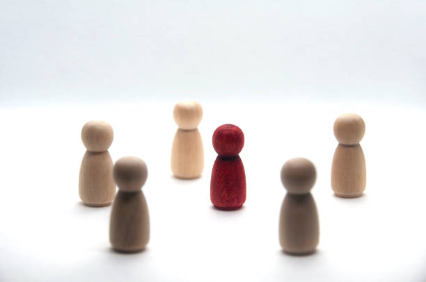 istock Wooden red figure surrounded by other figure on white background. 1455753579