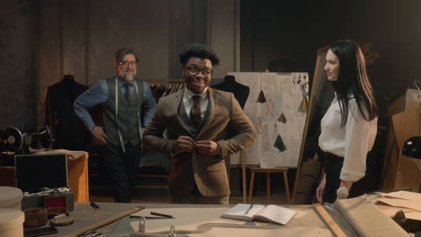 istock Tailor puts jacket on man in luxury designer atelier 1455753602