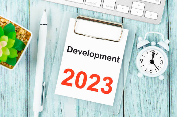 istock The Development 2023 text on clipboard with pen and keyboard computer on wooden background. 1455753889