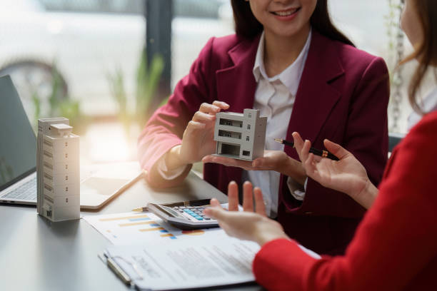 istock Real Estate Agent explain insurance and agreement contract to client before sign contract. Property insurance and security concept 1455754867
