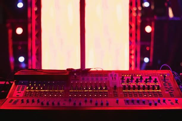 istock Sound mixing console for mixing audio signals in a recording studio with red lighting 1455755063
