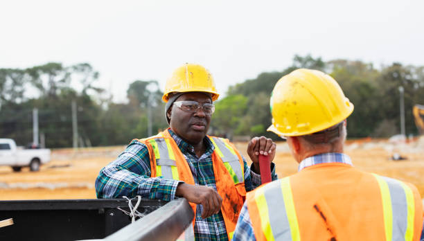 istock Multiracial construction workers talk by pickup truck 1455755092