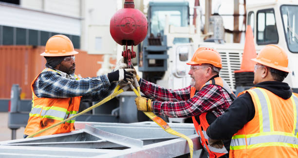 Construction workers prepare object to lift with crane stock photo