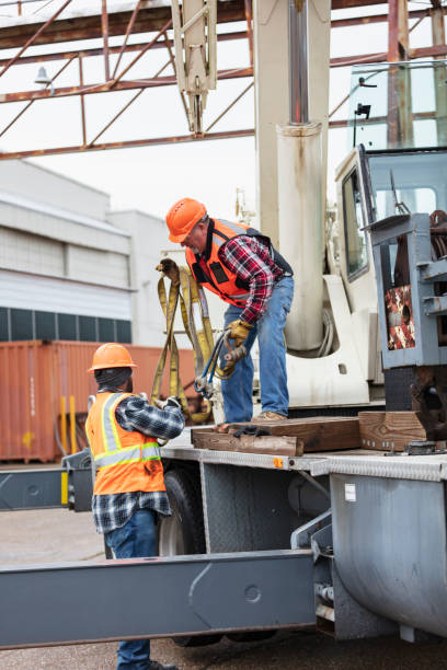 istock Crane operator takes lifting straps from coworker 1455755794