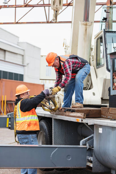 istock Crane operator takes lifting straps from coworker 1455755795