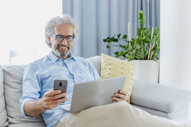 istock Senior man is using technology in the living room 1455756556