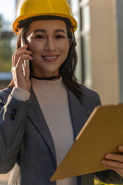 istock Young female site engineer with a safety vest and hardhat 1455757856