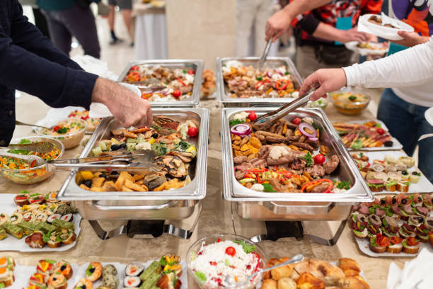 istock Hands picking up food from buffet catering table at the party. 1455758628
