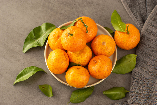 orange mandarin limes in a plate with a gray rusty background in conjunction with the Chinese New Year celebration