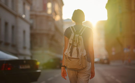 summer female solo trip to Europe, happy young woman walking on european street at sunset time. Vienna, Austria