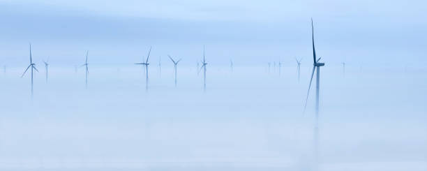 Wind Turbines on Thick Fog at Morning Aerial view of group wind turbines on morning thick fog. floating electric generator stock pictures, royalty-free photos & images