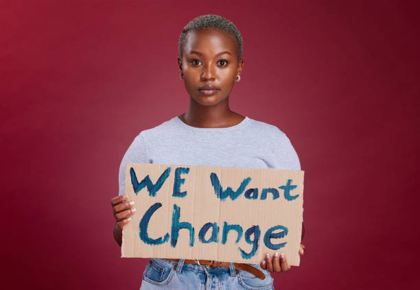 istock Black woman, protest and billboard message for change, text or voice against mockup studio background. Portrait of African American female activist with banner, poster or sign for empowerment or vote 1455764220