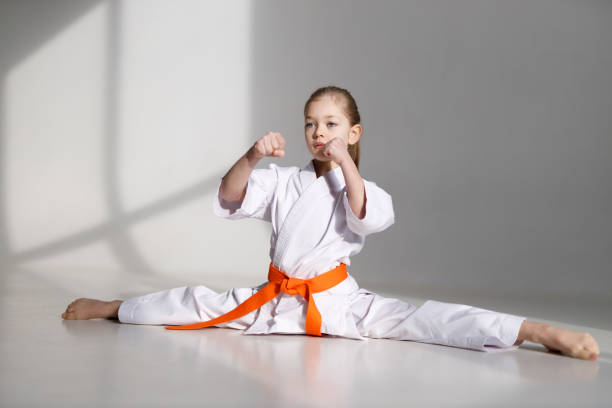 istock Split-legged karate block, little girl in a kimono on a white background. 1455767887