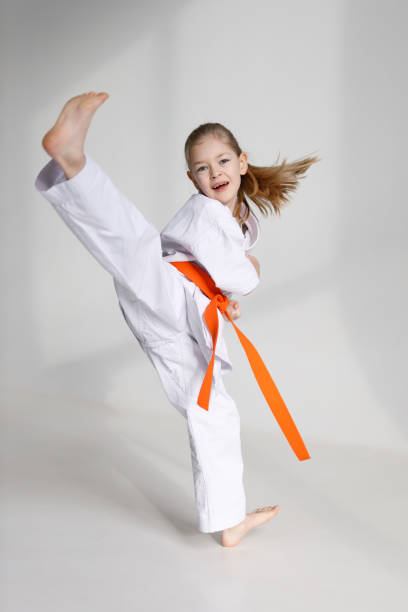 istock Little girl in kimono kicks, karate training. 1455767893