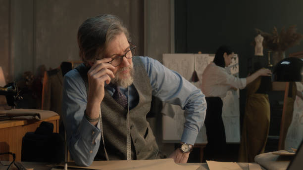 istock Tired male tailor sits at table in atelier 1455769150
