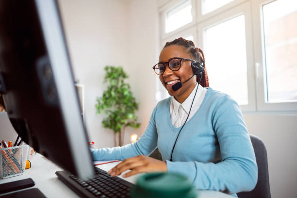 customer support specialist working at her office - bluetooth headset women customer imagens e fotografias de stock