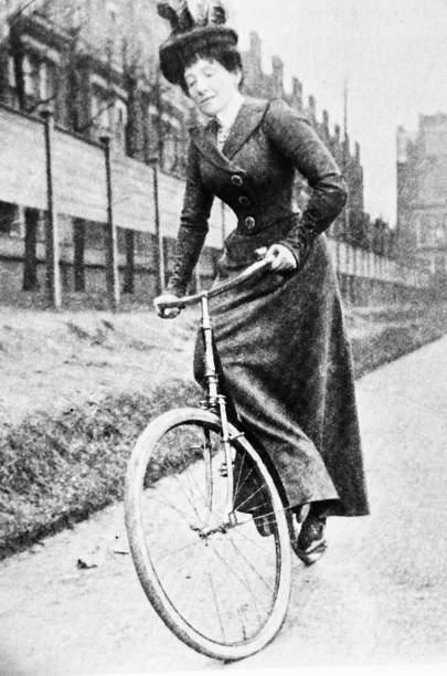 istock Woman in a long dress mounting a bicycle 1455770316