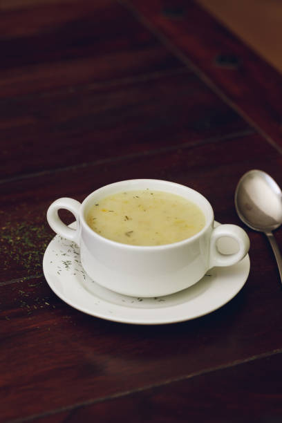 istock Vertical shot of soup with a spoon and brown table on the background 1455770444